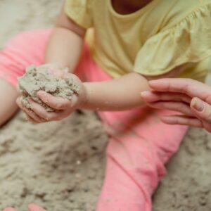 a toddler playing in sand