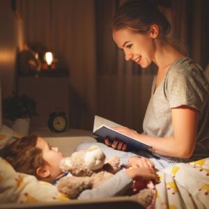 a mother reading to a child with soft lights and nightlights on