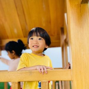 a boy and girl playing on a playset